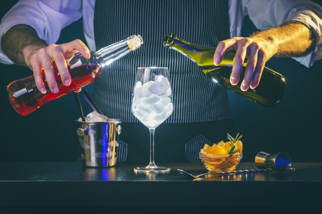 Bartender pouring liquor into cocktail glass
